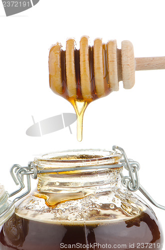 Image of Jar of honey with wooden drizzler