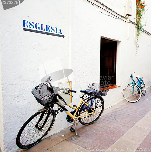 Image of two bicycles at a white wall