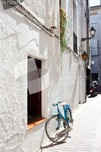 Image of blue bicycle at a white wall