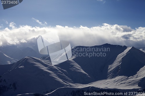 Image of Winter mountains in evening and paragliders
