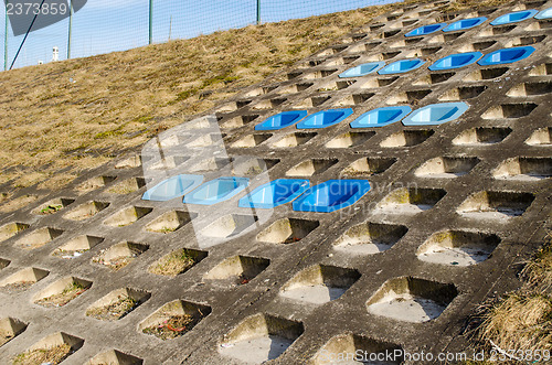 Image of cement slope surface mounted blue chairs rest 