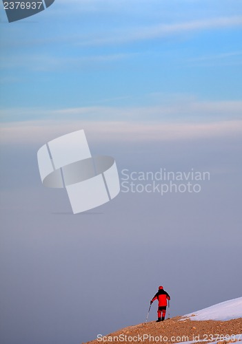 Image of Hiker on edge of cliff in sunrise