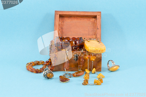 Image of amber stone jewelry retro wooden box on blue 