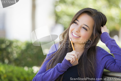 Image of Pensive Mixed Race Female Student with Pencil on Campus