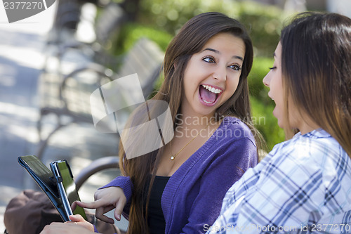 Image of Two Mixed Race Students Using Touch Pad Computer Outside