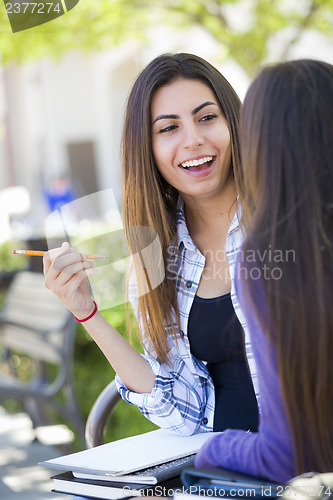 Image of Expressive Young Mixed Race Female Sitting and Talking with Girl