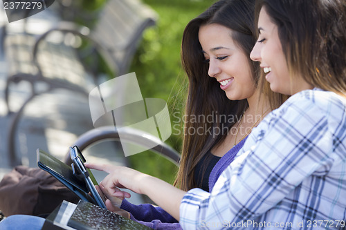 Image of Two Mixed Race Students Using Touch Pad Computer Outside