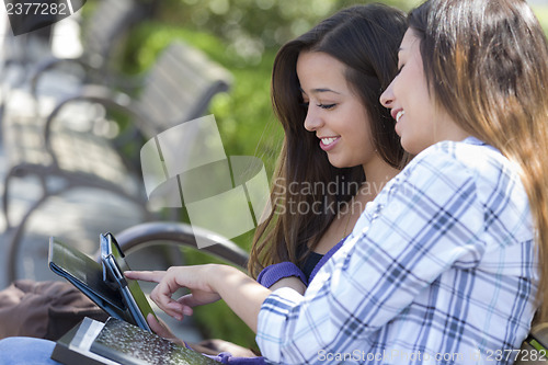 Image of Two Mixed Race Students Using Touch Pad Computer Outside