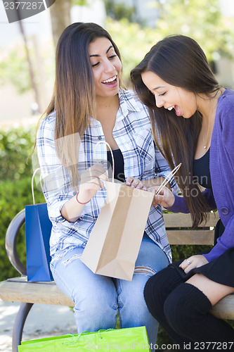 Image of Young Adult Mixed Race Women Looking Into Their Shopping Bags