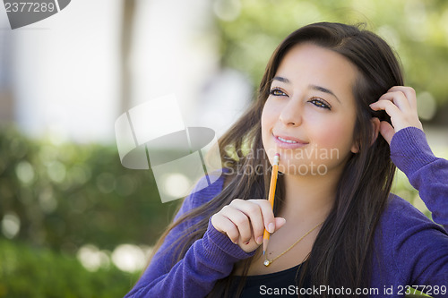 Image of Pensive Mixed Race Female Student with Pencil on Campus