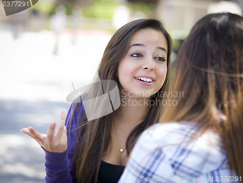Image of Expressive Young Mixed Race Female Sitting and Talking with Girl