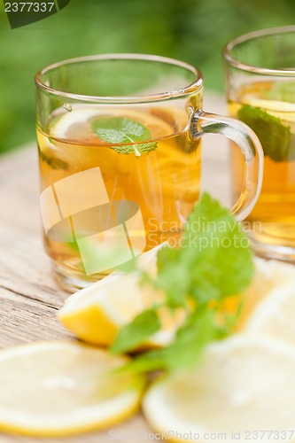 Image of fresh tasty hot tea lemon and mint outdoor in summer 