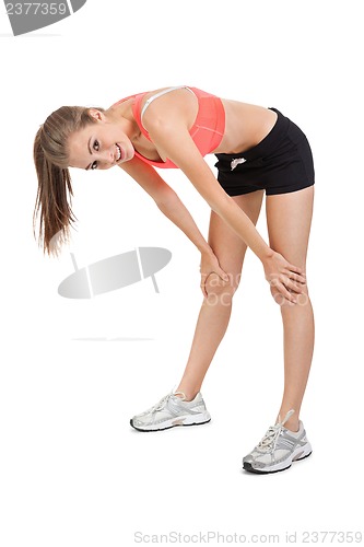 Image of young attractive woman stretching legs after jogging isolated