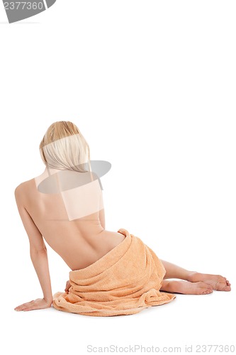 Image of young blonde woman sitting on towel naked back isolated 