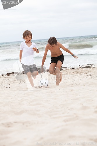 Image of happy family father two kids playing football on beach summer 
