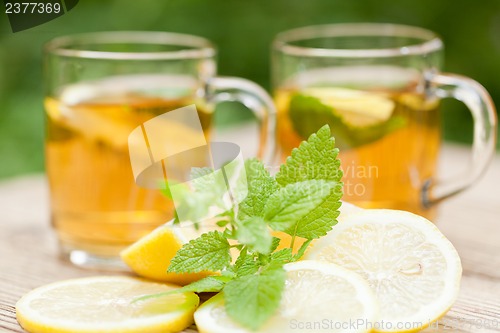 Image of fresh tasty hot tea lemon and mint outdoor in summer 