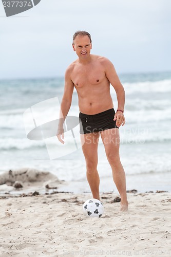 Image of happy family father two kids playing football on beach summer 