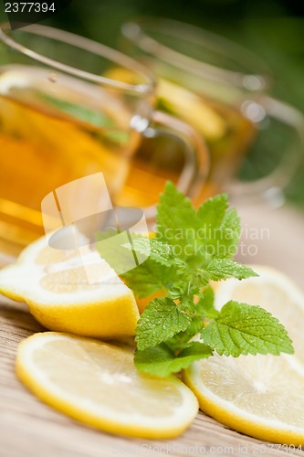 Image of fresh tasty hot tea lemon and mint outdoor in summer 