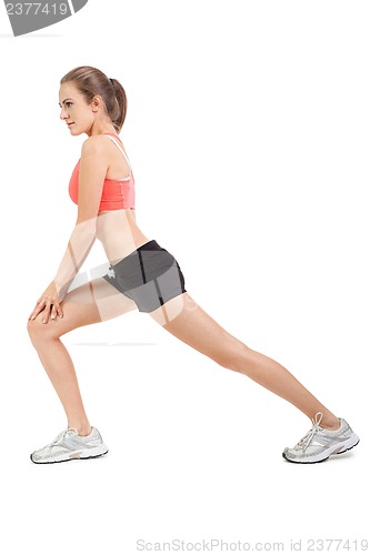 Image of young attractive woman stretching legs after jogging isolated