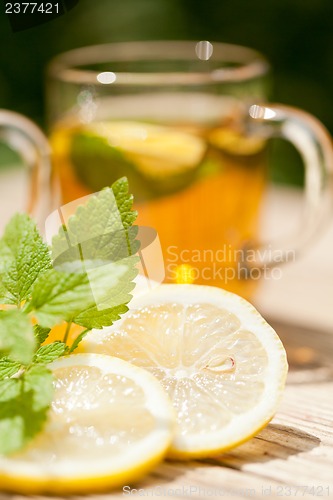 Image of fresh tasty hot tea lemon and mint outdoor in summer 