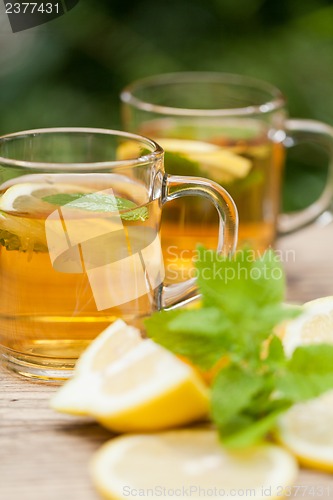 Image of fresh tasty hot tea lemon and mint outdoor in summer 