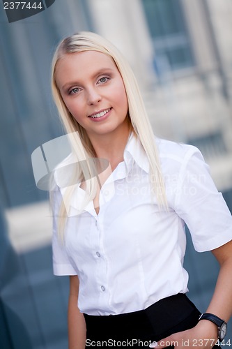 Image of attractive young successful smiling business woman standing outdoor 