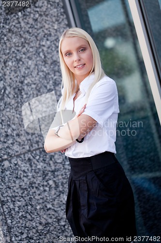 Image of attractive young successful smiling business woman standing outdoor 