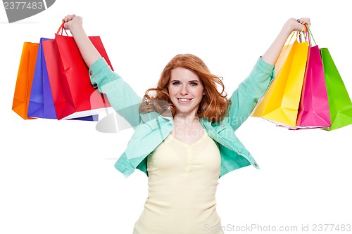 Image of smiling young redhead girl with colorful shoppingbags 