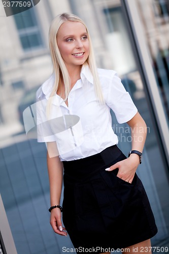 Image of attractive young successful smiling business woman standing outdoor 