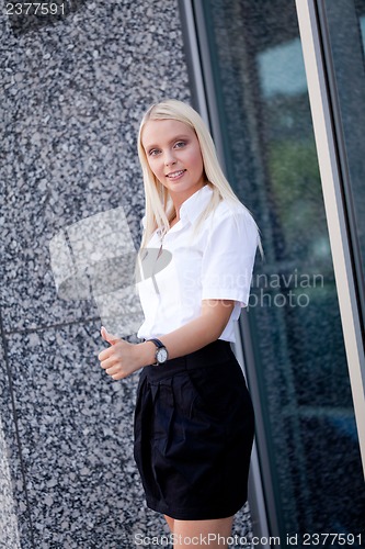 Image of attractive young successful smiling business woman standing outdoor 
