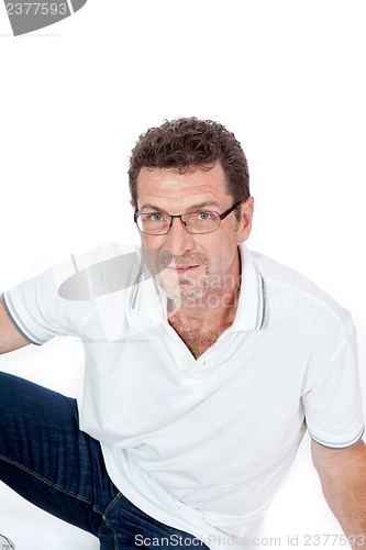 Image of attractive healthy adult man sitting on floor with jeans isolated