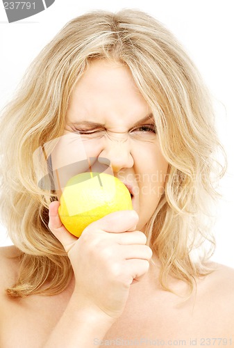 Image of lovely blond biting lemon