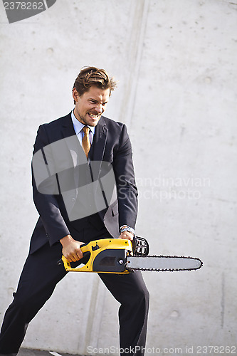 Image of Crazy businessman with a chainsaw