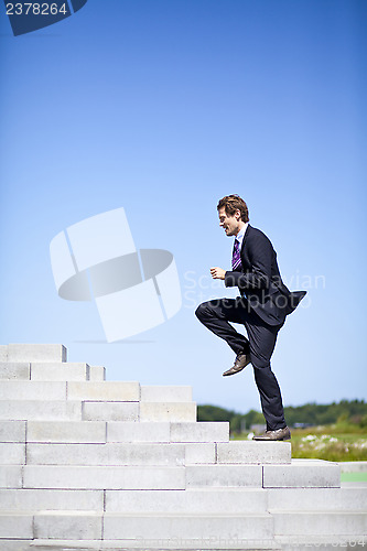 Image of Businessman running up stairs