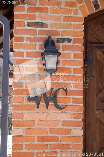 Image of wc toilet sign symbol red brick wall retro lamp 