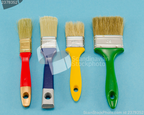 Image of hand paint brush color different size on blue 