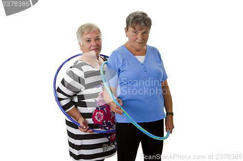 Image of Senior lady doing gymnastic with hula hoop