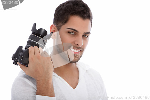 Image of Handsome young photographer holding a camera