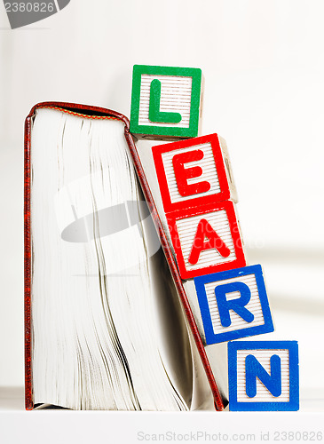 Image of Learn alphabet Block besides book