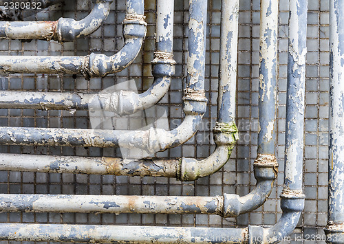 Image of Series of parallel old pipes on wall