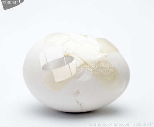 Image of Cracked white egg with plastic plaster
