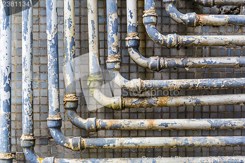 Image of Series of parallel old pipes on wall