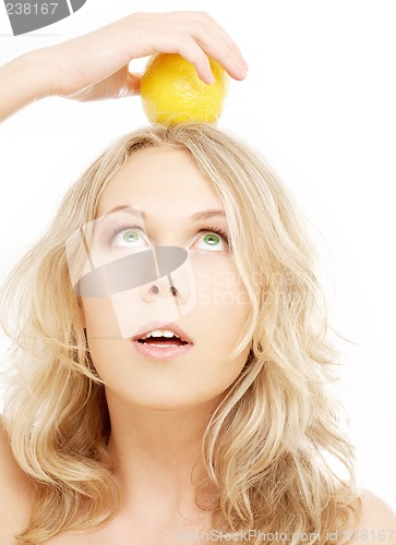 Image of healthy blond holding lemon on her head