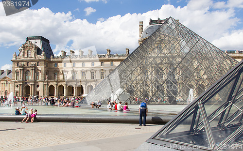 Image of PARIS - JULY 28, 2013. Tourists enjoy the weather at the Louvre 