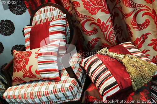 Image of Luxurious red chair with satin pillows