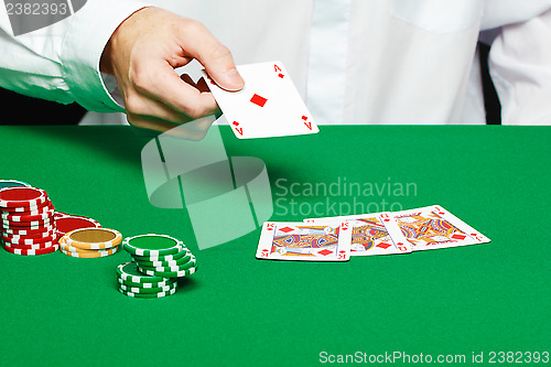 Image of player's hand throws a playing card