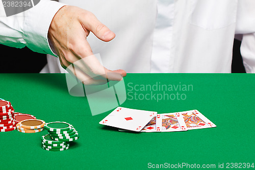 Image of player's hand throws a playing card