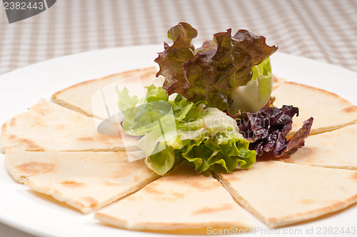 Image of garlic pita bread pizza with salad on top