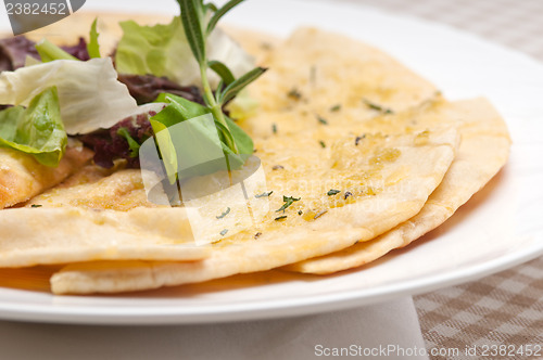 Image of garlic pita bread pizza with salad on top