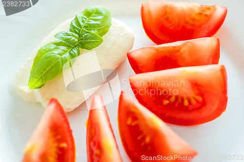 Image of Italian appetizer tomatoes with mozarella and basil